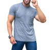 Homem sorrindo e posando com uma camisa cinza escuro e cala jeans, mostrando um relgio prateado.