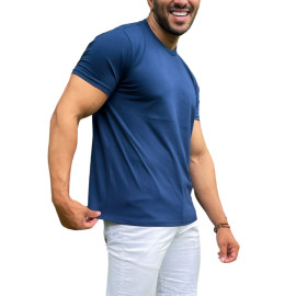 Homem sorridente vestindo uma camiseta azul marinho e calas brancas, posando para a foto.