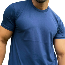 Modelo usando uma camiseta masculina azul escuro, mostrando o tronco e os braos em uma pose casual.