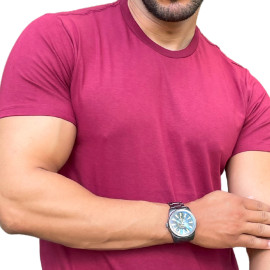Homem usando uma camiseta vinho, mostrando o brao e um relgio de pulso.