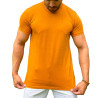 Modelo vestindo uma camiseta masculina caramelo, segurando a parte inferior da camiseta com as duas mos.