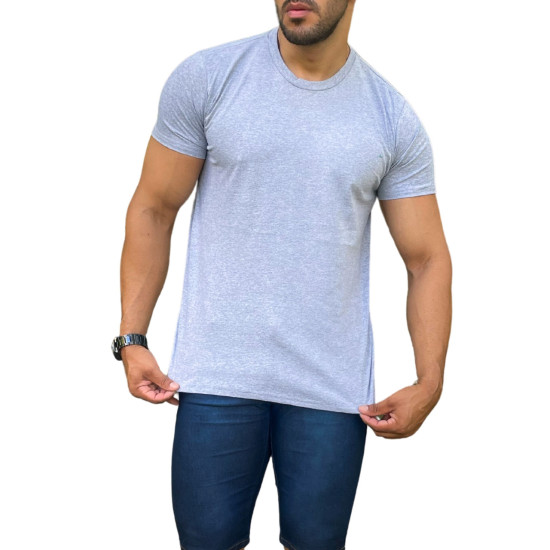 Homem segurando uma camisa cinza claro, com calas jeans escuras, em um fundo branco.